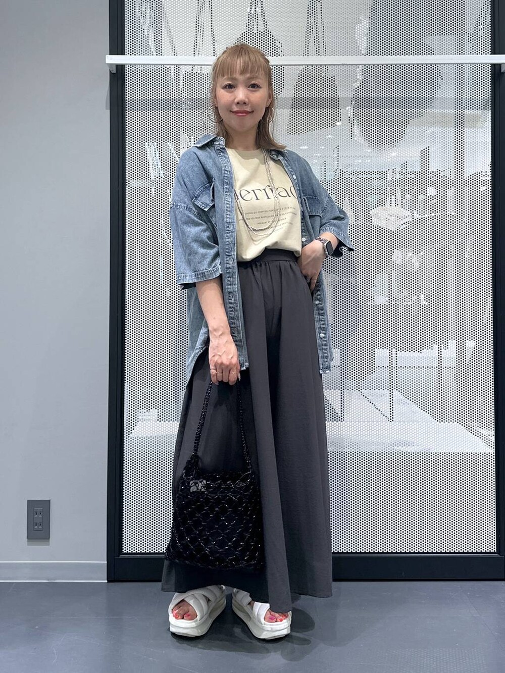 ブラック系のかごバッグ、ブルー系のシャツ/ブラウス、グレー系のその他パンツを着用したレディースの夏コーディネートの2枚目の写真