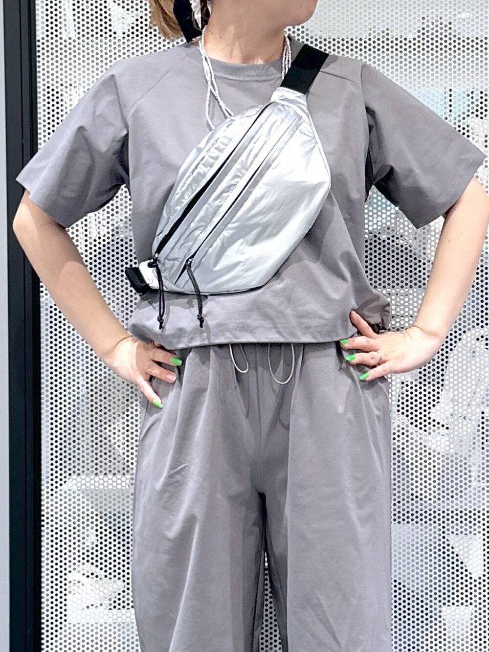 シルバー系のボディバッグ/ウエストポーチ、グレー系のTシャツ/カットソー、グレー系のその他パンツを着用したレディースの春コーディネートの3枚目の写真