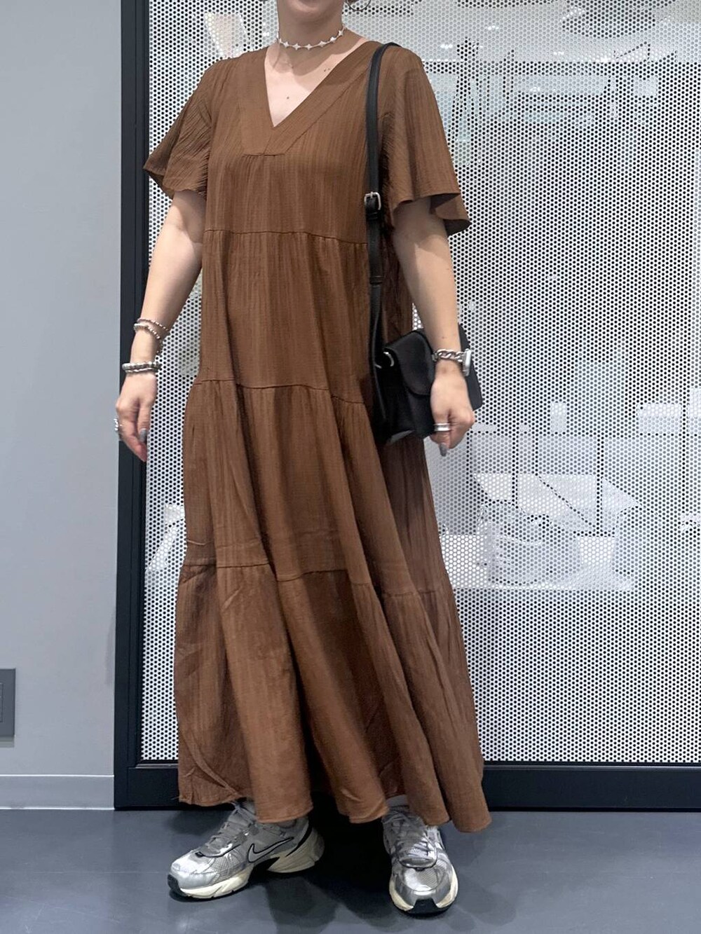 ブラック系のショルダーバッグ、その他のピアス（両耳用）、シルバー系のデジタル腕時計を着用したレディースの夏コーディネートの4枚目の写真