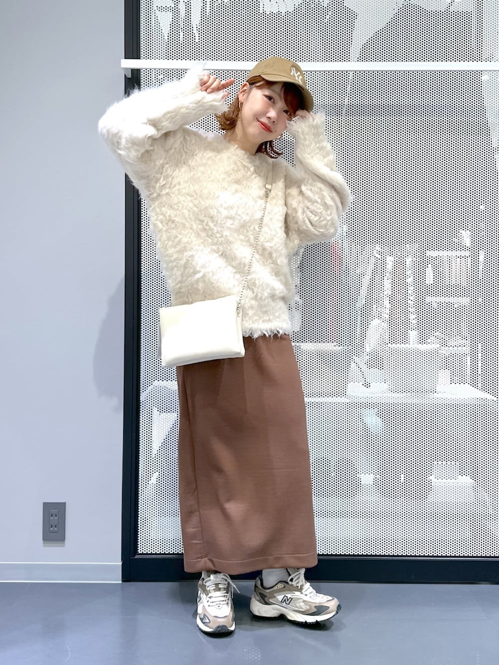 ベージュ系のベスト、ホワイト系のショルダーバッグ、ベージュ系のニット/セーターを着用したレディースの秋コーディネートの2枚目の写真