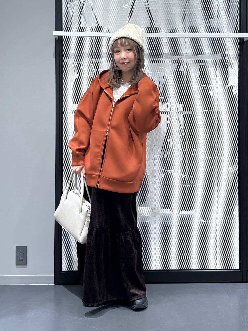 グレー系のボストンバッグ、ブラウン系のパーカー、ホワイト系のTシャツ/カットソーを着用したレディースの秋コーディネートの2枚目の写真