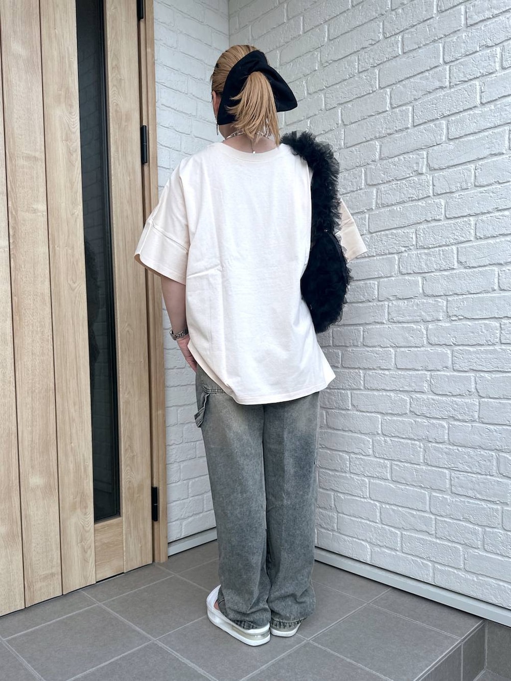 ブラック系のショルダーバッグ、ホワイト系のサンダル、その他のデニムパンツを着用したレディースの夏コーディネートの3枚目の写真