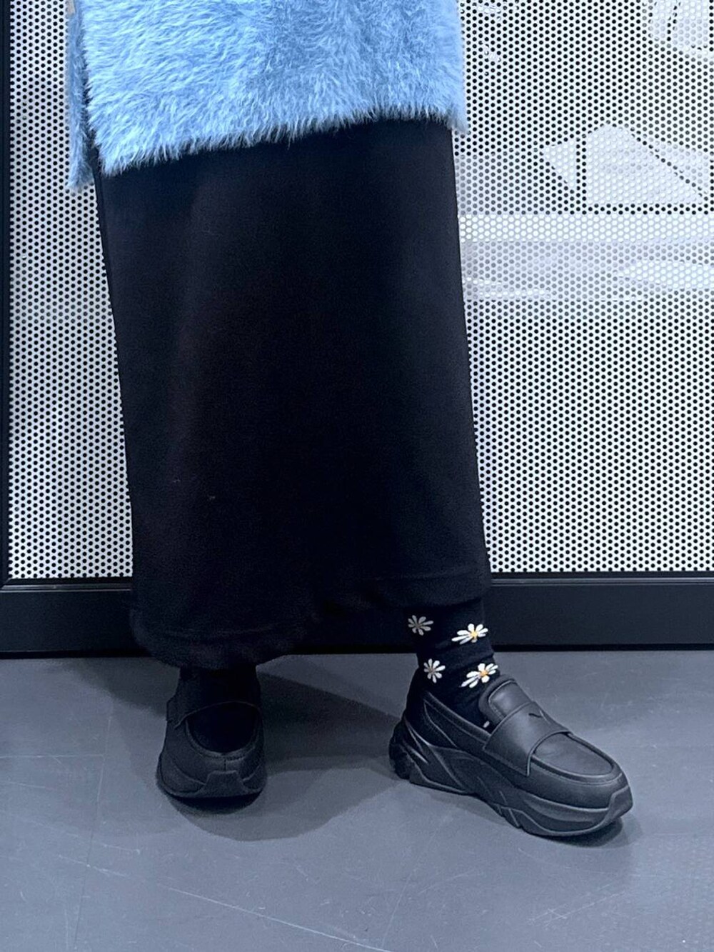 ホワイト系のTシャツ/カットソー、ブラック系のスカート、ブルー系のベストを着用したレディースの秋コーディネートの5枚目の写真