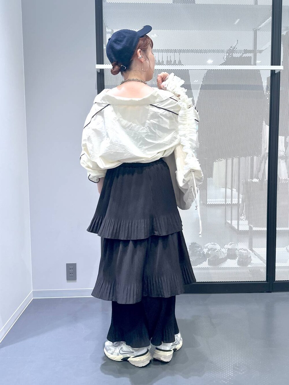 ブラック系のスカート、ホワイト系のショルダーバッグ、ベージュ系のブルゾンを着用したレディースの秋コーディネートの3枚目の写真