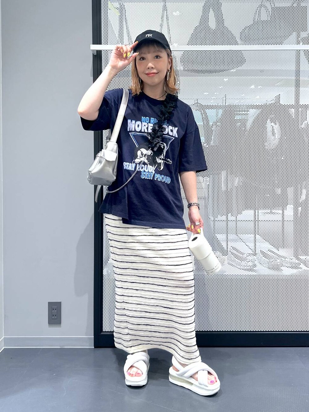 ホワイト系のトートバッグ、ホワイト系のスカート、ブルー系のTシャツ/カットソーを着用したレディースの春コーディネートの2枚目の写真