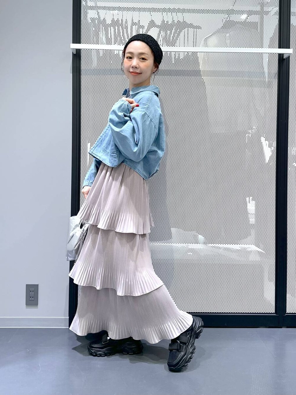 ブラック系のスニーカー、ブルー系のデニムジャケット、シルバー系のショルダーバッグを着用したレディースの春コーディネートの5枚目の写真