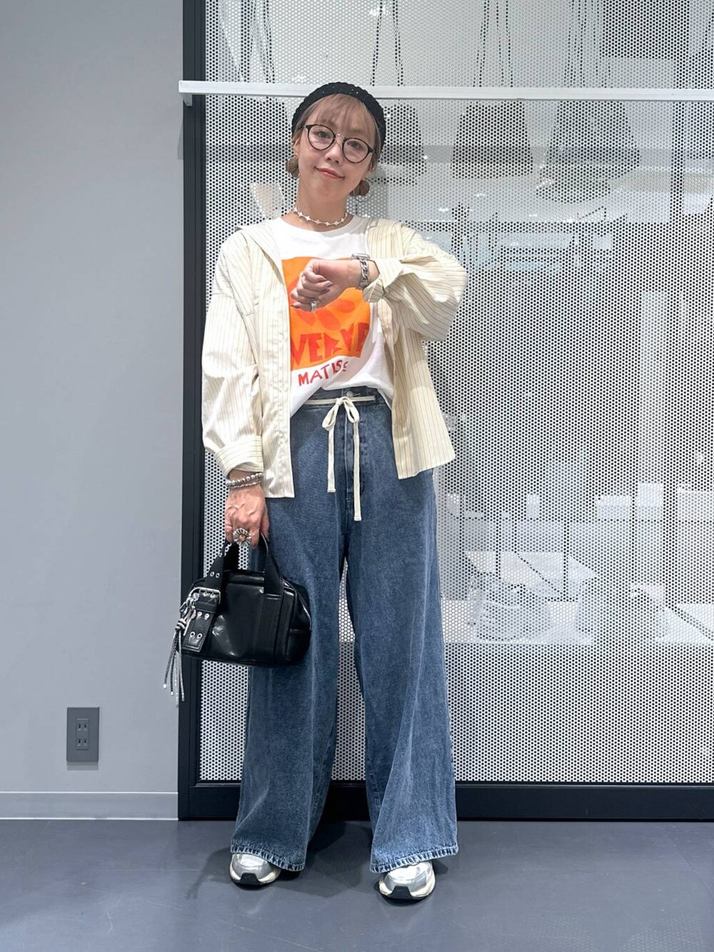 ブラック系のショルダーバッグ、ブルー系のデニムパンツ、ホワイト系のTシャツ/カットソーを着用したレディースの夏コーディネートの2枚目の写真