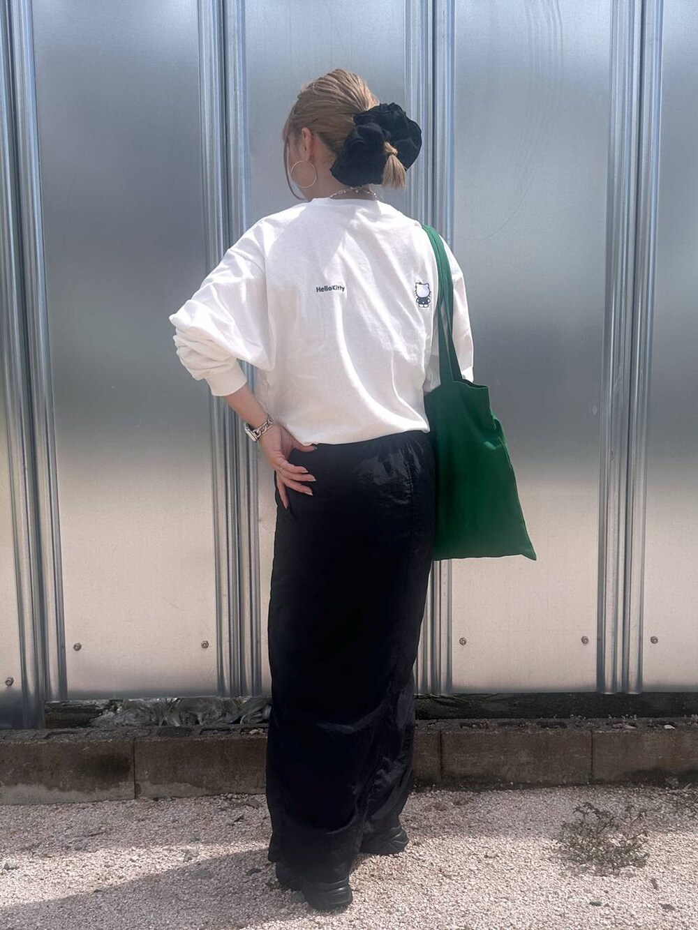 ブラック系のスカート、グリーン系のトートバッグ、その他のピアス(両耳用)を着用したレディースの秋コーディネートの6枚目の写真