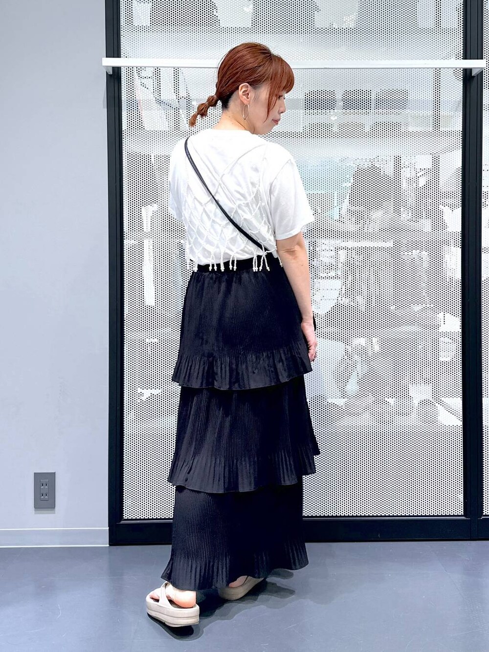 ブラック系のショルダーバッグ、ブラック系のスカート、ベージュ系のサンダルを着用したレディースの夏コーディネートの3枚目の写真