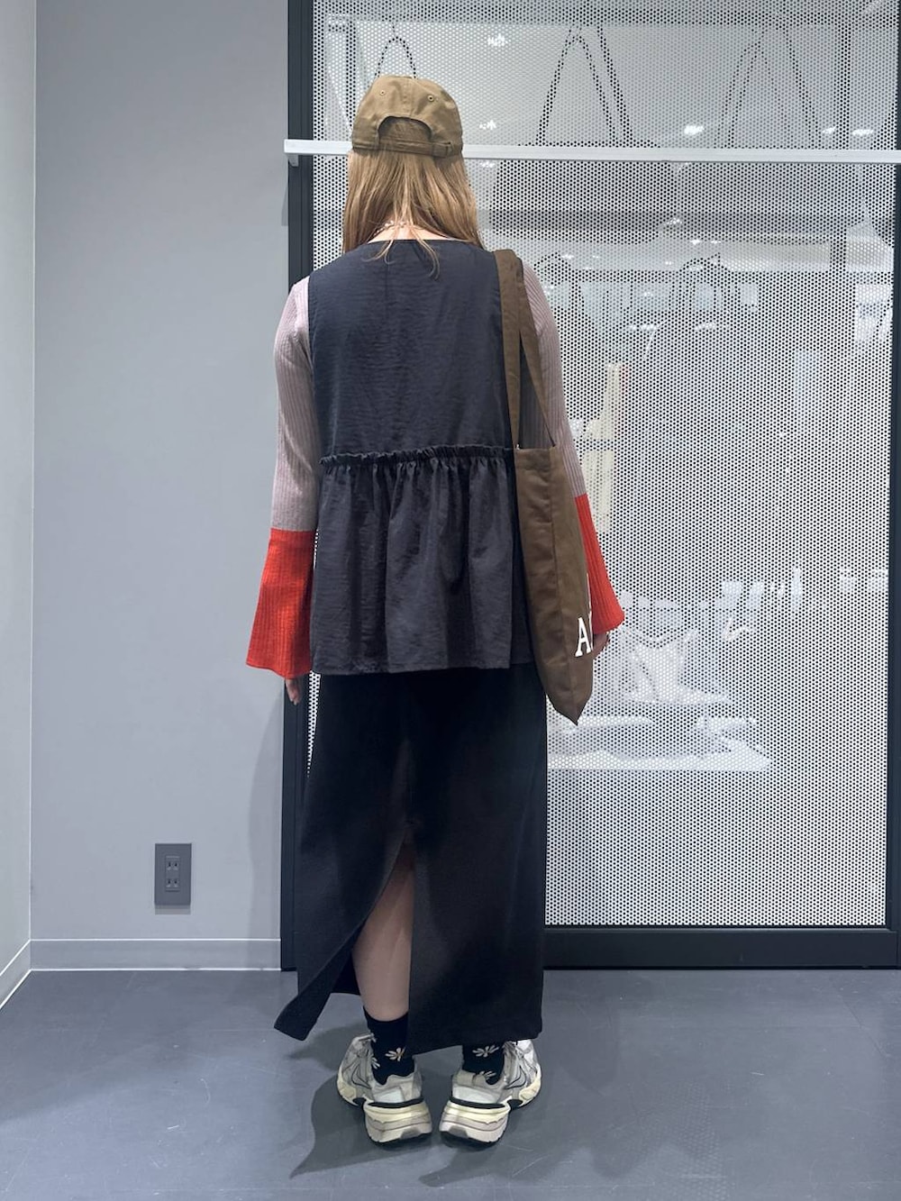 ブラック系のスカート、ブラウン系のトートバッグ、ブラウン系のニット/セーターを着用したレディースの秋コーディネートの3枚目の写真