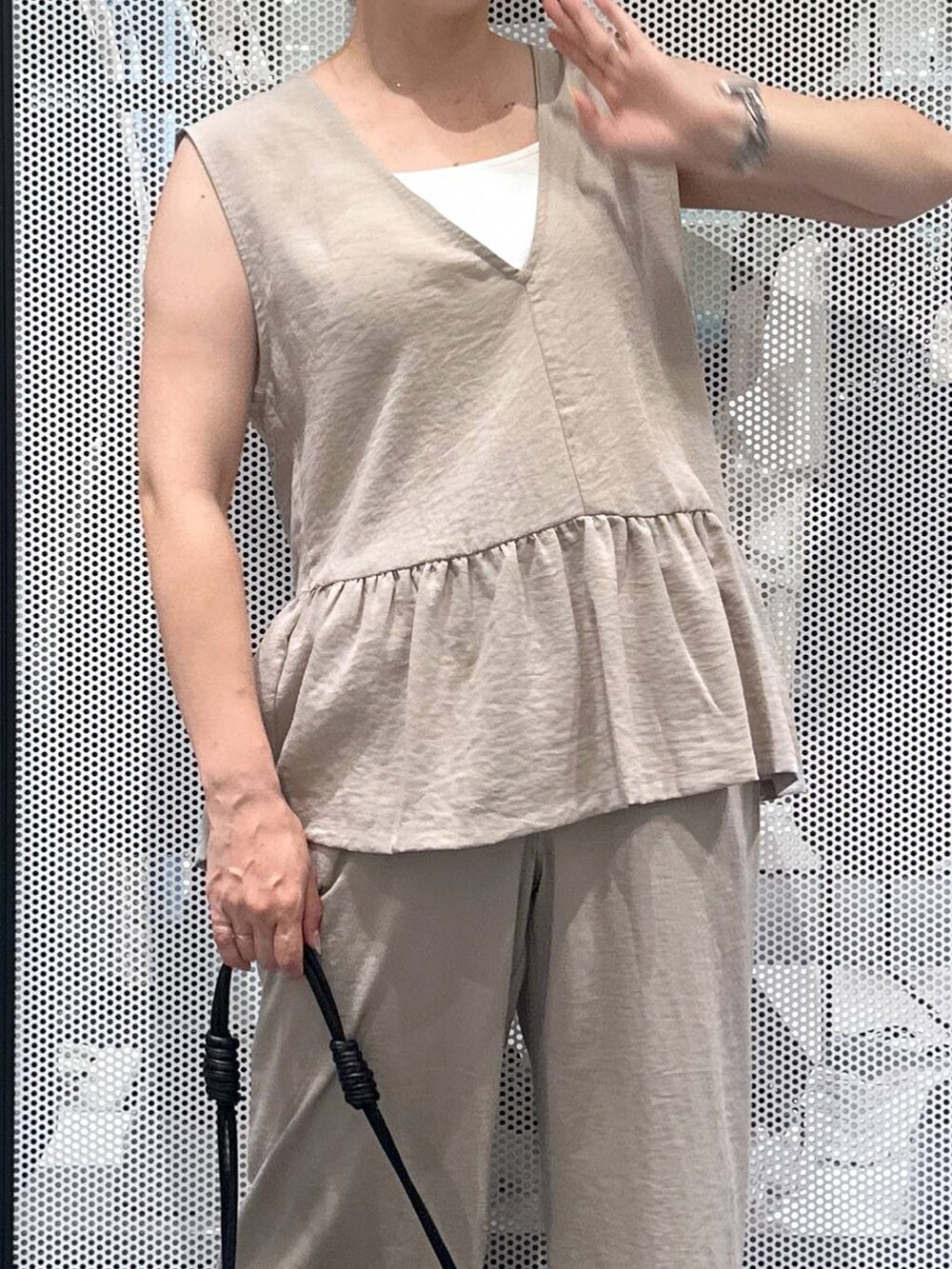 ブラック系のショルダーバッグ、ベージュ系のその他パンツ、ベージュ系のベストを着用したレディースの夏コーディネートの4枚目の写真