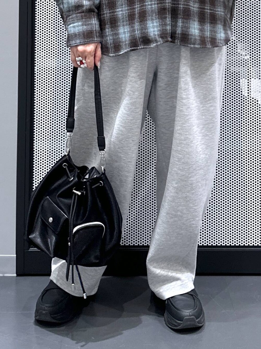 ブラック系のショルダーバッグ、ホワイト系のTシャツ/カットソー、グレー系のスウェットパンツを着用したレディースの秋コーディネートの5枚目の写真