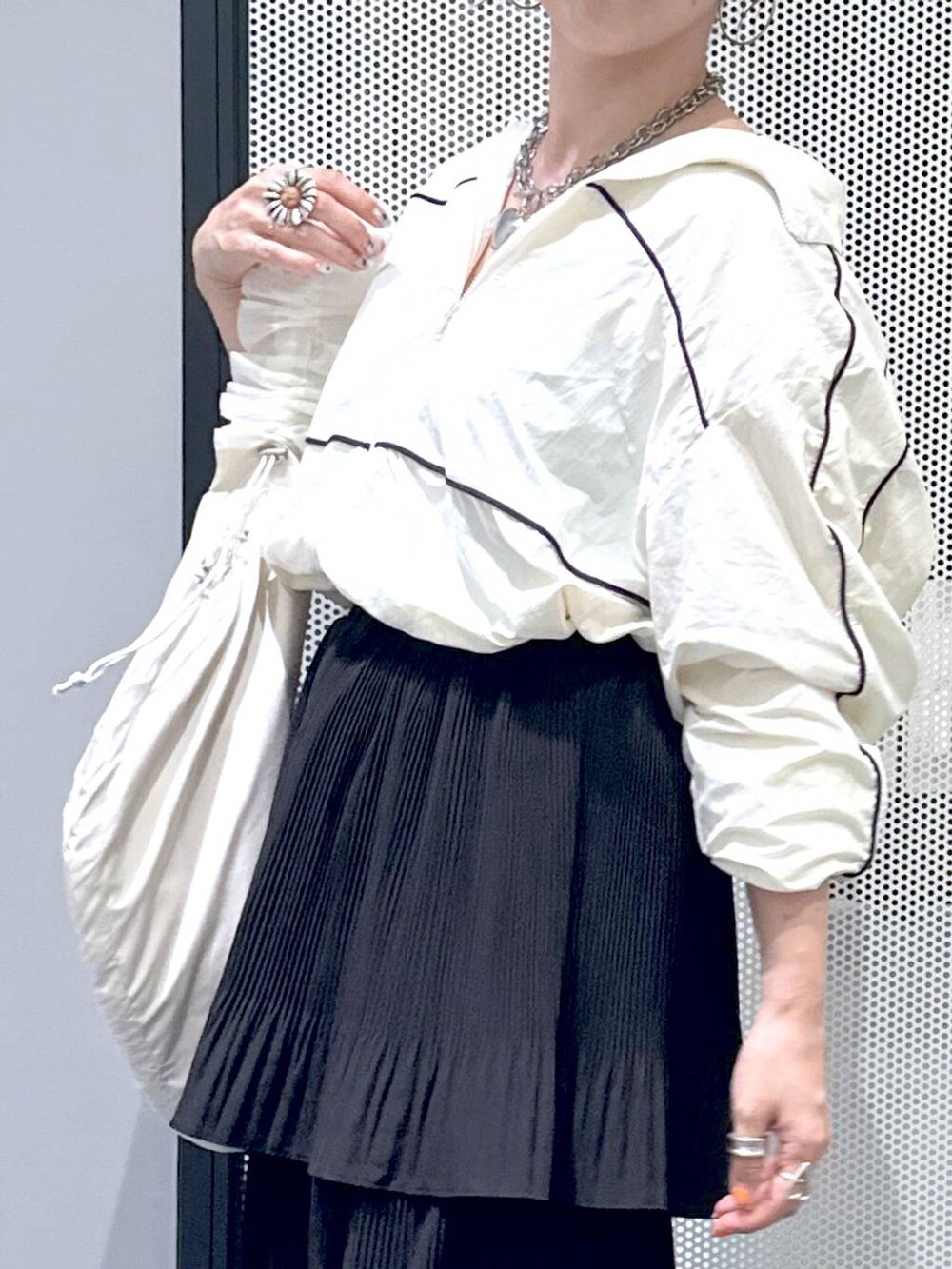 ブラック系のスカート、ホワイト系のショルダーバッグ、ベージュ系のブルゾンを着用したレディースの秋コーディネートの4枚目の写真