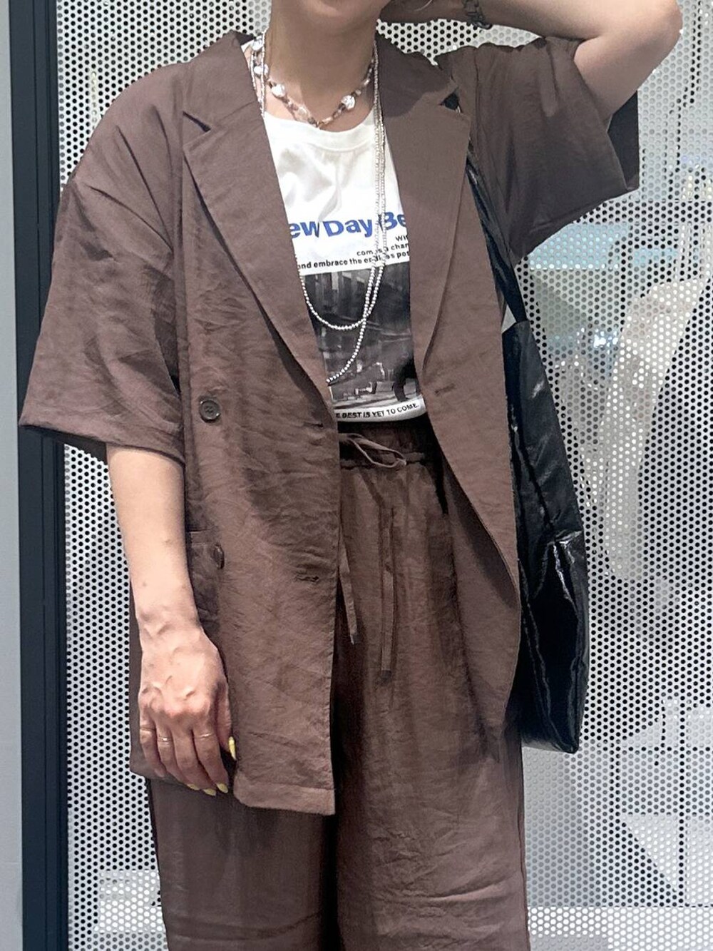 ブラック系のトートバッグ、ブラウン系のテーラードジャケット、ブラウン系のその他パンツを着用したレディースの春コーディネートの4枚目の写真