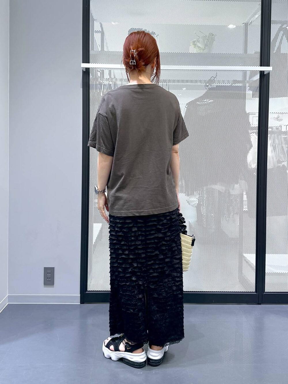グレー系のTシャツ/カットソー、ブラック系のスカート、ホワイト系のショルダーバッグを着用したレディースの夏コーディネートの4枚目の写真
