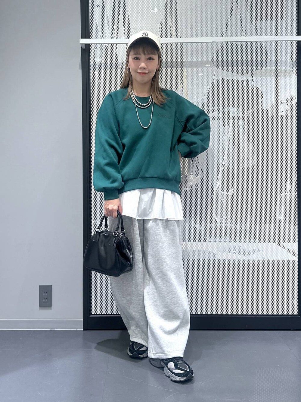 ブルー系のトートバッグ、ベージュ系のブルゾン、ブラック系のショルダーバッグを着用したレディースの冬コーディネートの2枚目の写真