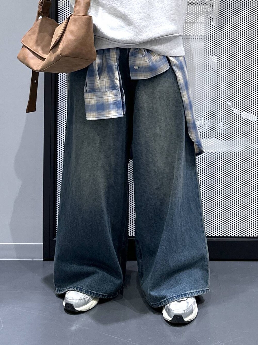 イエロー系のショルダーバッグ、ブルー系のデニムパンツ、ブラウン系のニット/セーターを着用したレディースの秋コーディネートの5枚目の写真