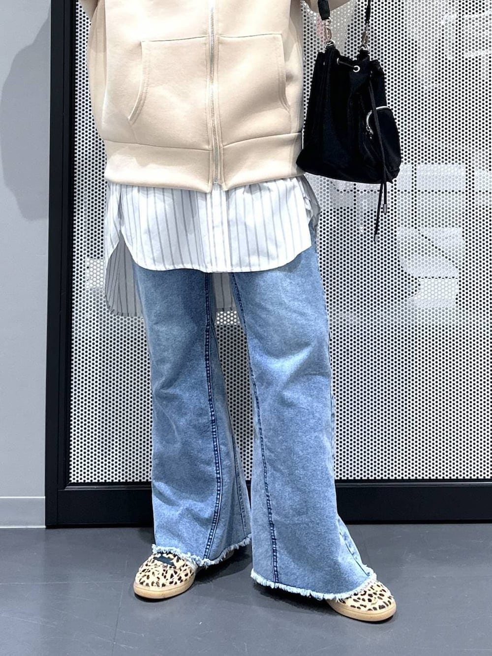 ホワイト系のシャツ/ブラウス、ブラック系のショルダーバッグ、ブルー系のデニムパンツを着用したレディースの春コーディネートの4枚目の写真