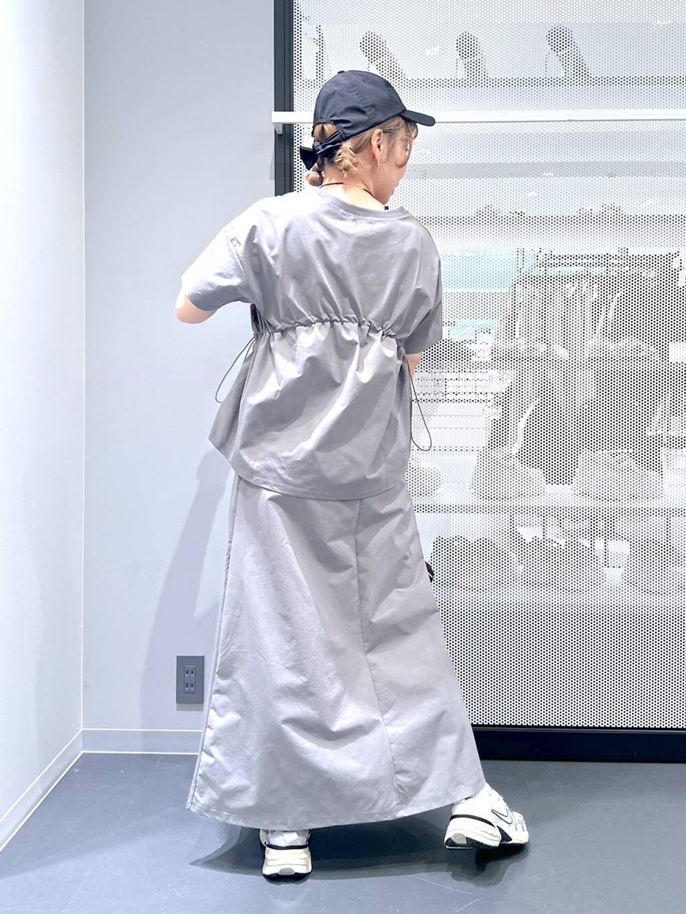 ブラック系のショルダーバッグ、グレー系のスカート、グレー系のTシャツ/カットソーを着用したレディースの春コーディネートの5枚目の写真