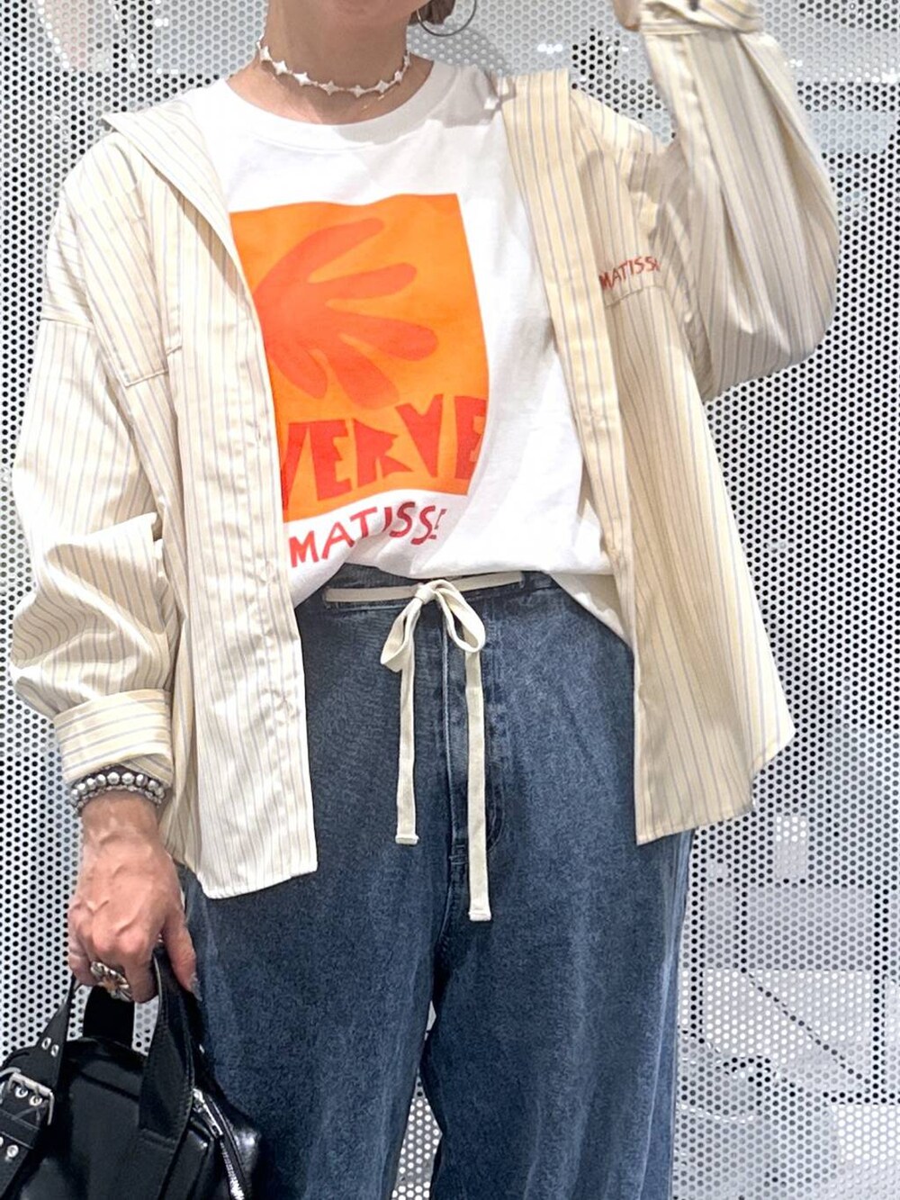 ブラック系のショルダーバッグ、ブルー系のデニムパンツ、ホワイト系のTシャツ/カットソーを着用したレディースの夏コーディネートの4枚目の写真