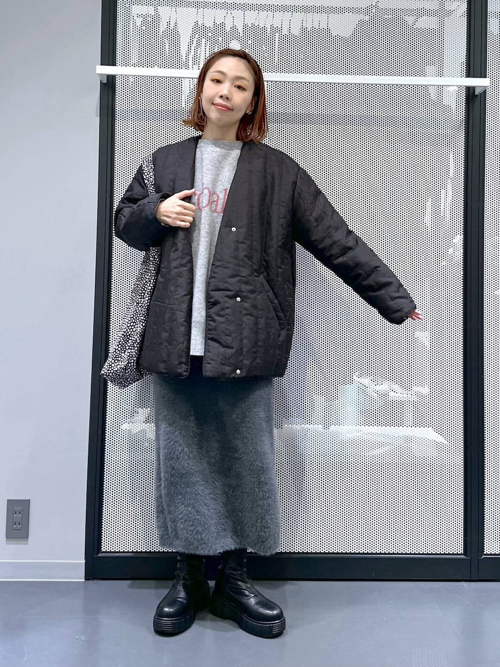 ブラック系のトートバッグ、ブラック系のブーツ、ブラック系のブルゾンを着用したレディースの冬コーディネートの3枚目の写真