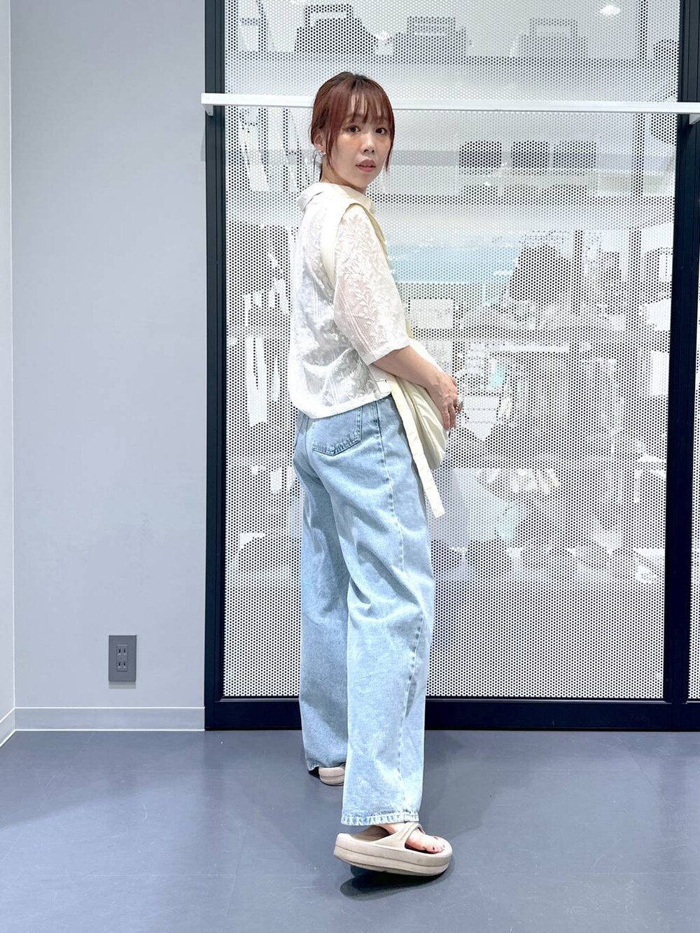 ベージュ系のシャツ/ブラウス、ブルー系のデニムパンツ、ホワイト系のショルダーバッグを着用したレディースの夏コーディネートの3枚目の写真