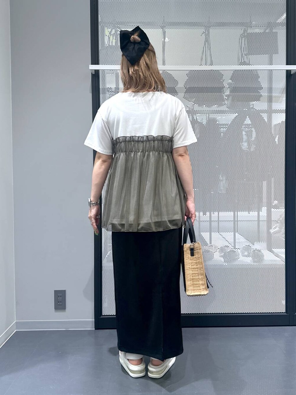 ベージュ系のショルダーバッグ、ブラック系のスカート、グリーン系のTシャツ/カットソーを着用したレディースの春コーディネートの2枚目の写真