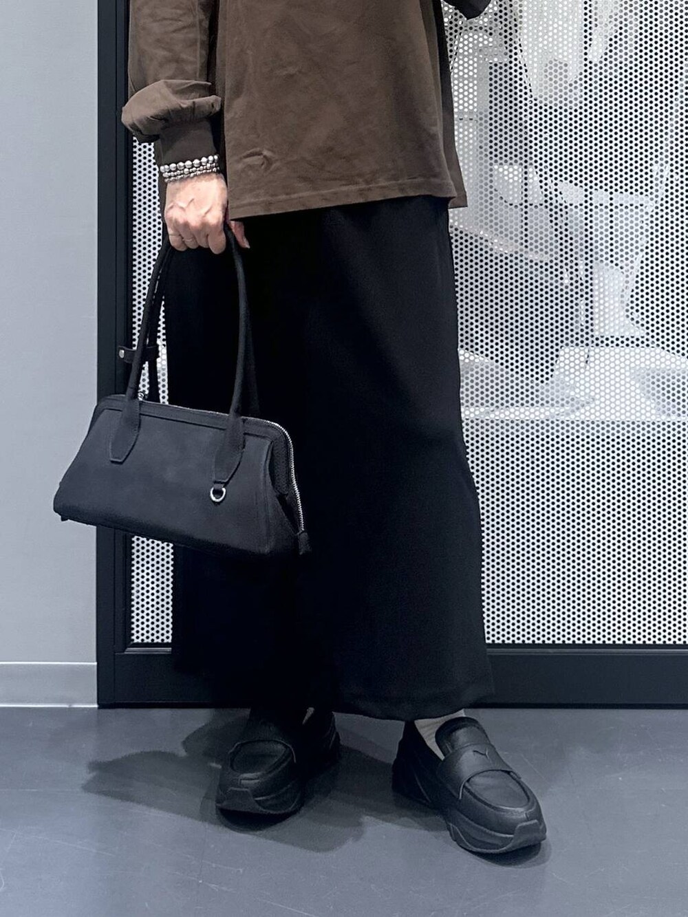 ブラック系のスカート、ブラック系のハンドバッグ、その他のピアス（両耳用）を着用したレディースの秋コーディネートの4枚目の写真