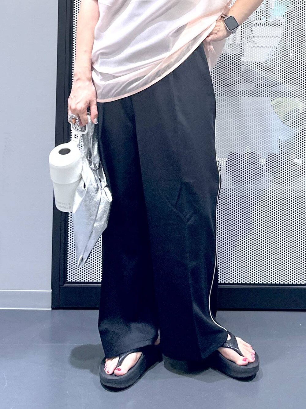 シルバー系のショルダーバッグ、ブラック系のスラックス、ブラック系のサンダルを着用したレディースの夏コーディネートの6枚目の写真