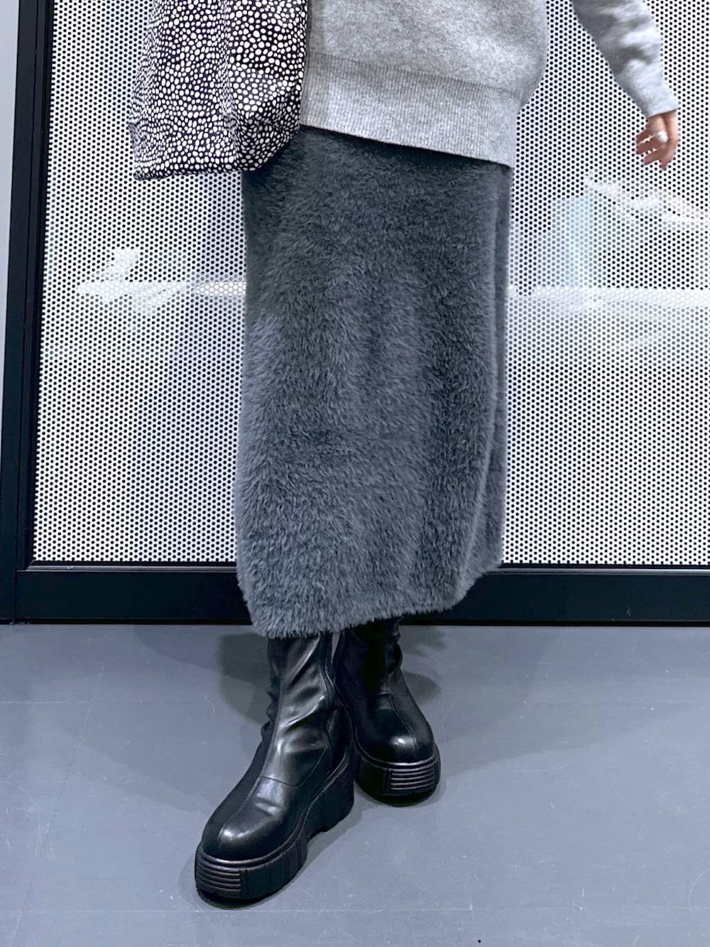 ブラック系のトートバッグ、ブラック系のブーツ、ブラック系のブルゾンを着用したレディースの冬コーディネートの9枚目の写真