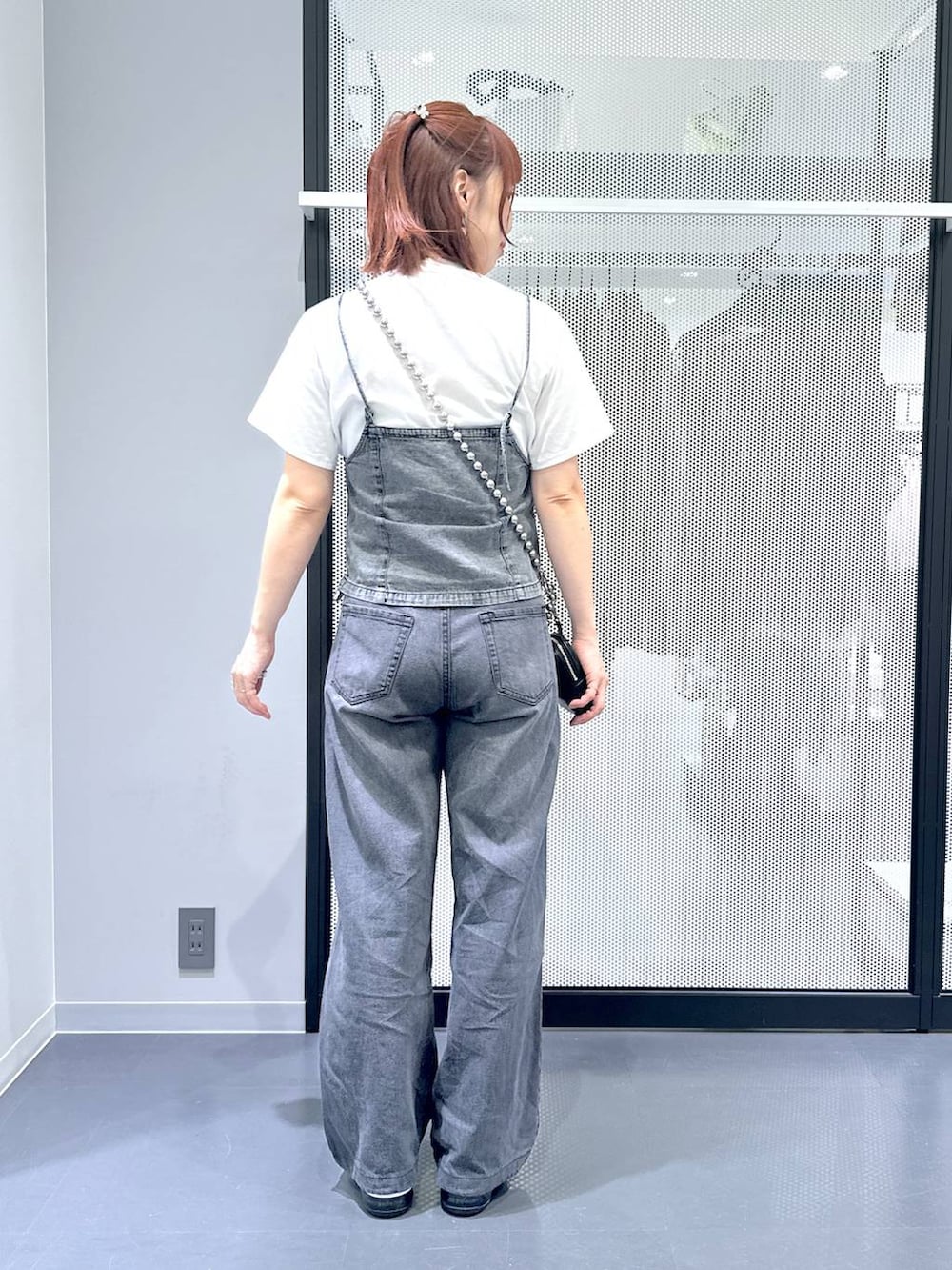 ブラック系のデニムパンツ、グレー系のベスト、ホワイト系のTシャツ/カットソーを着用したレディースの夏コーディネートの4枚目の写真