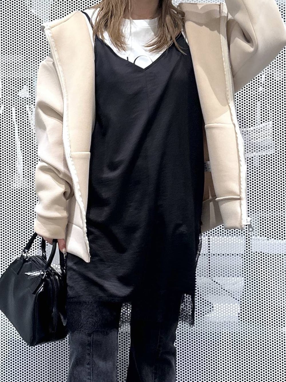 ブラック系のショルダーバッグ、ホワイト系のTシャツ/カットソー、ブラック系のデニムパンツを着用したレディースの冬コーディネートの3枚目の写真