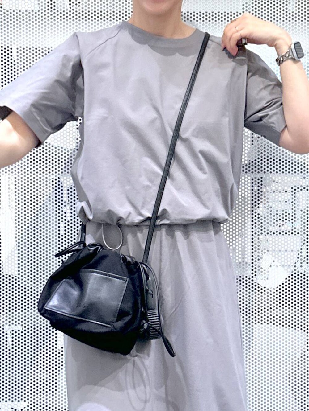 ブラック系のショルダーバッグ、ベージュ系のサンダル、グレー系のTシャツ/カットソーを着用したレディースの夏コーディネートの4枚目の写真