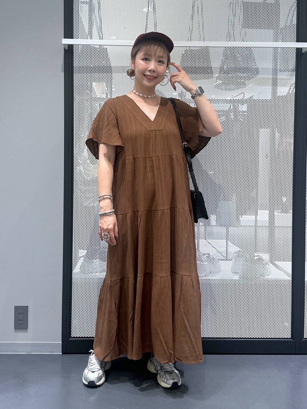 ブラック系のショルダーバッグ、その他のピアス（両耳用）、シルバー系のデジタル腕時計を着用したレディースの夏コーディネートの2枚目の写真