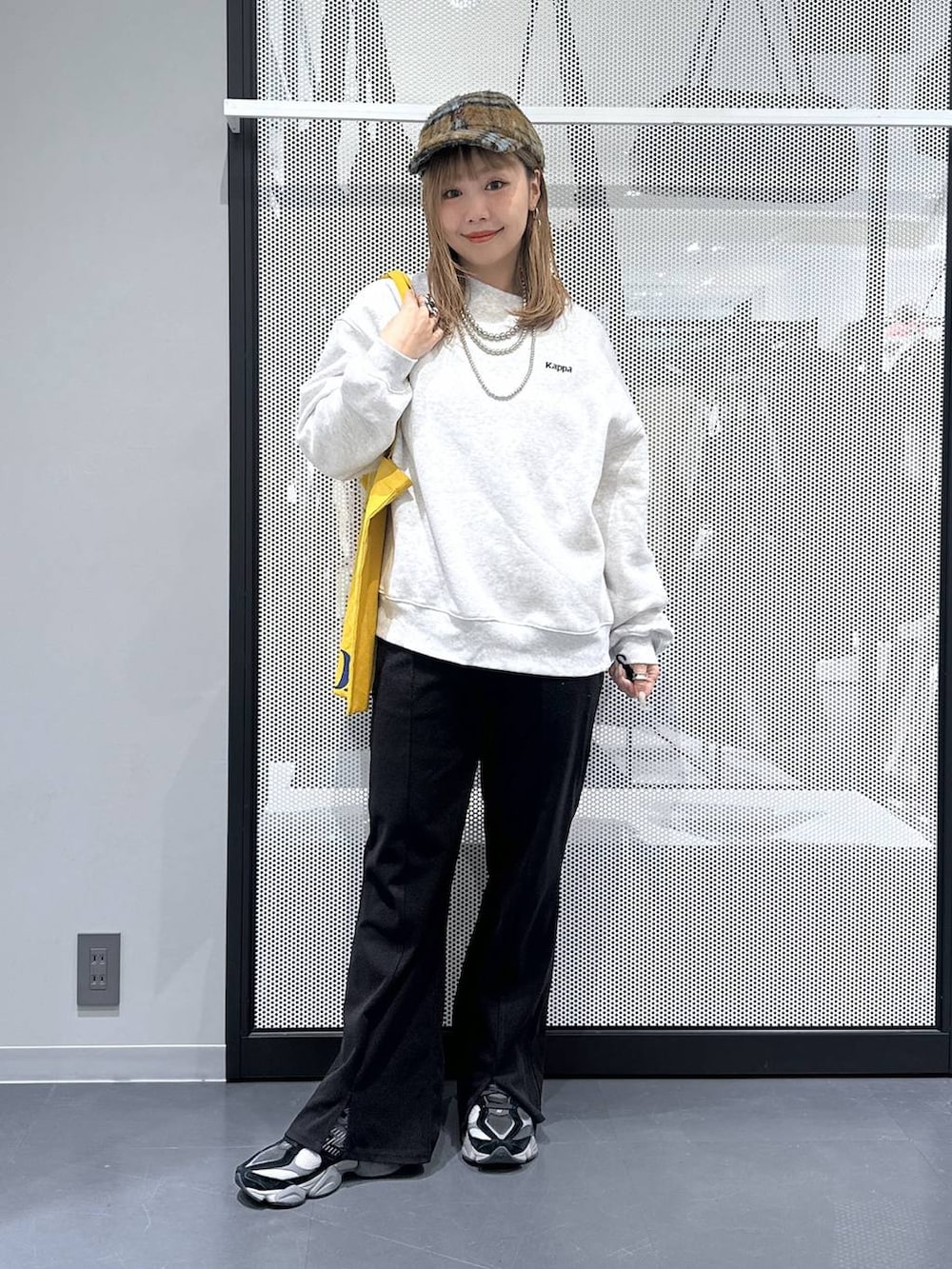 イエロー系のトートバッグ、ブラック系のダウンジャケット/コート、ブラック系のその他パンツを着用したレディースの冬コーディネートの2枚目の写真