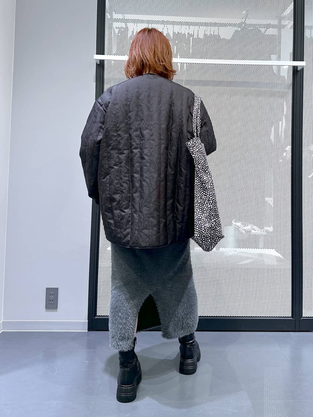 ブラック系のトートバッグ、ブラック系のブーツ、ブラック系のブルゾンを着用したレディースの冬コーディネートの4枚目の写真