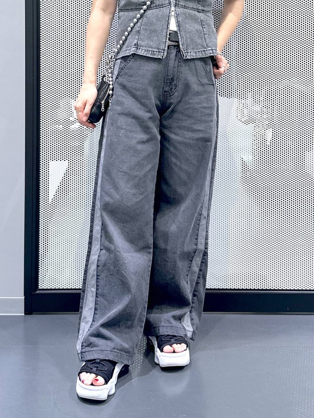 ブラック系のデニムパンツ、グレー系のベスト、ホワイト系のTシャツ/カットソーを着用したレディースの夏コーディネートの6枚目の写真