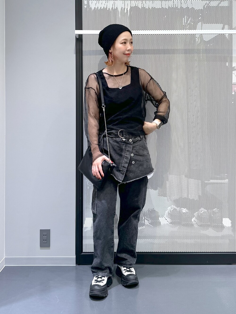 ブラック系のTシャツ/カットソー、ブラック系のデニムパンツ、ホワイト系のスニーカーを着用したレディースの秋コーディネートの2枚目の写真