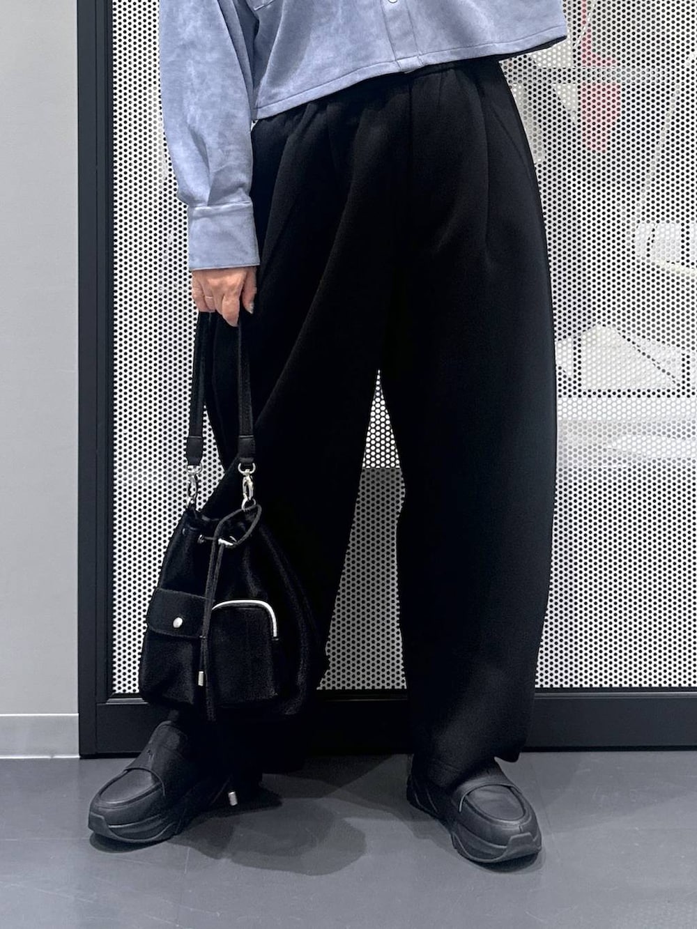 ホワイト系のタンクトップ、ブラック系のショルダーバッグ、ブラック系のスウェットパンツを着用したレディースの秋コーディネートの4枚目の写真