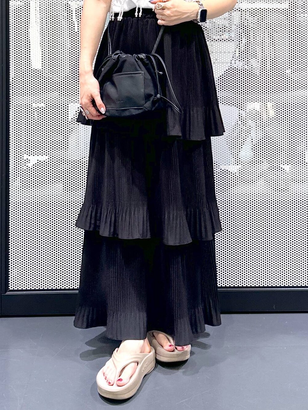 ブラック系のショルダーバッグ、ブラック系のスカート、ベージュ系のサンダルを着用したレディースの夏コーディネートの6枚目の写真