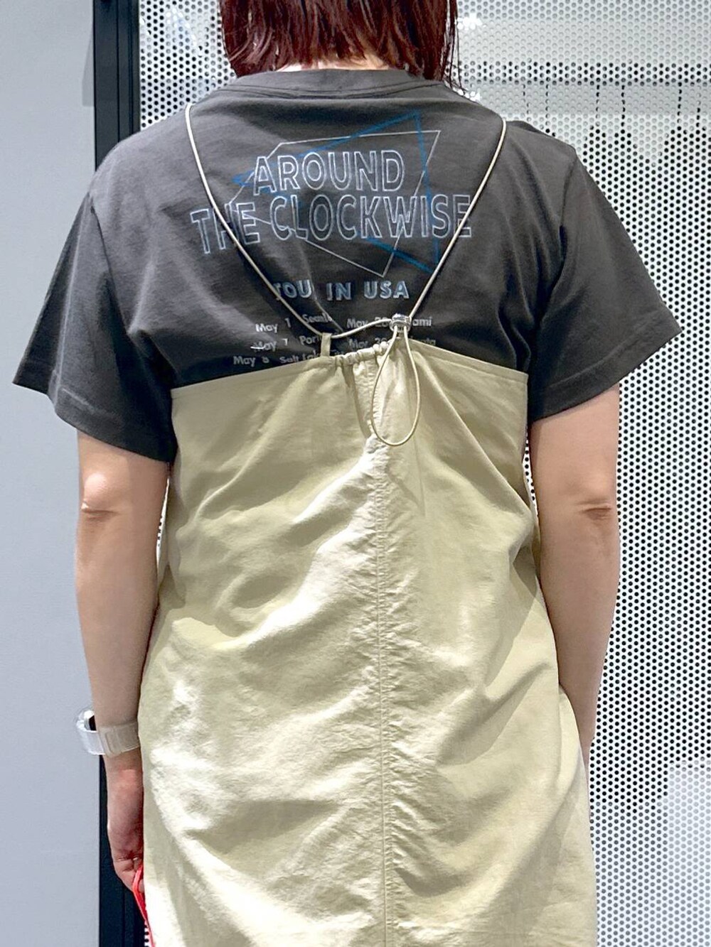 ベージュ系のワンピース、ブラック系のサンダル、グレー系のTシャツ/カットソーを着用したレディースの春コーディネートの5枚目の写真