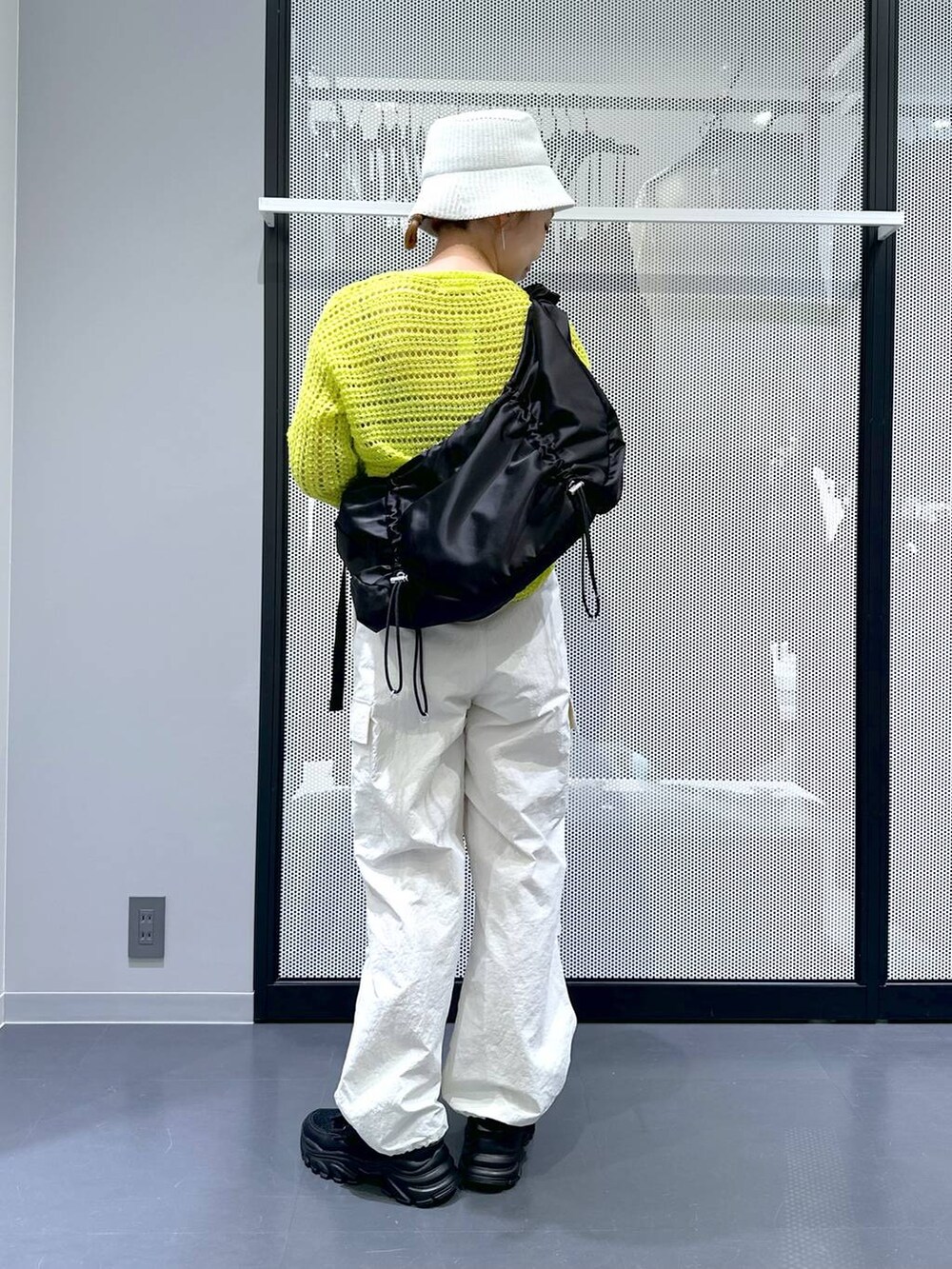 ブラック系のスニーカー、ホワイト系のカーゴパンツ、グリーン系のニット/セーターを着用したレディースの春コーディネートの3枚目の写真