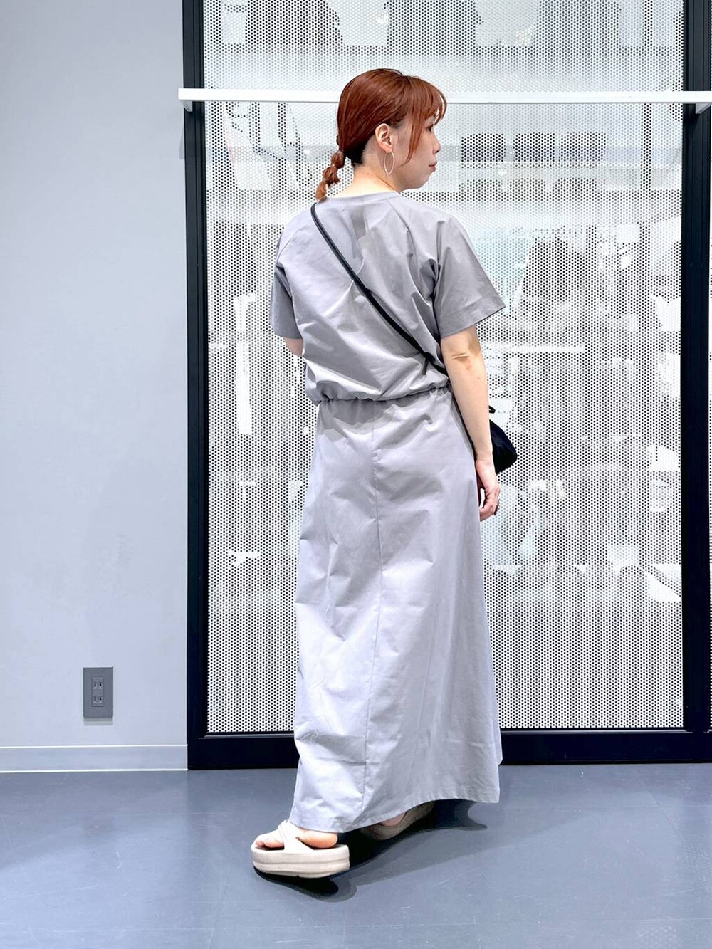 ブラック系のショルダーバッグ、ベージュ系のサンダル、グレー系のTシャツ/カットソーを着用したレディースの夏コーディネートの3枚目の写真