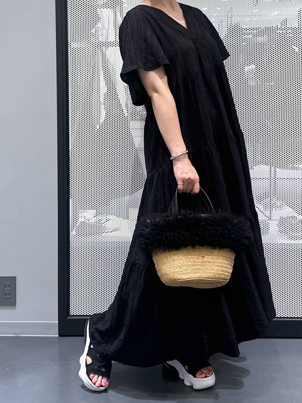 ベージュ系のショルダーバッグ、ブラック系のワンピース、ブラック系のサンダルを着用したレディースの春コーディネートの4枚目の写真