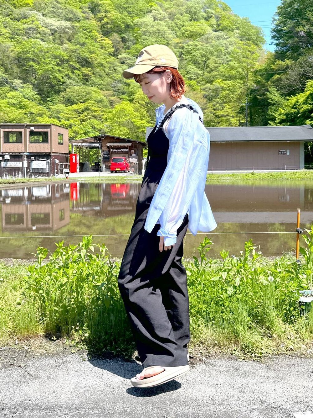 ブルー系のシャツ/ブラウス、ベージュ系のサンダル、ブラック系のサロペット/オーバーオールを着用したレディースの春コーディネートの4枚目の写真