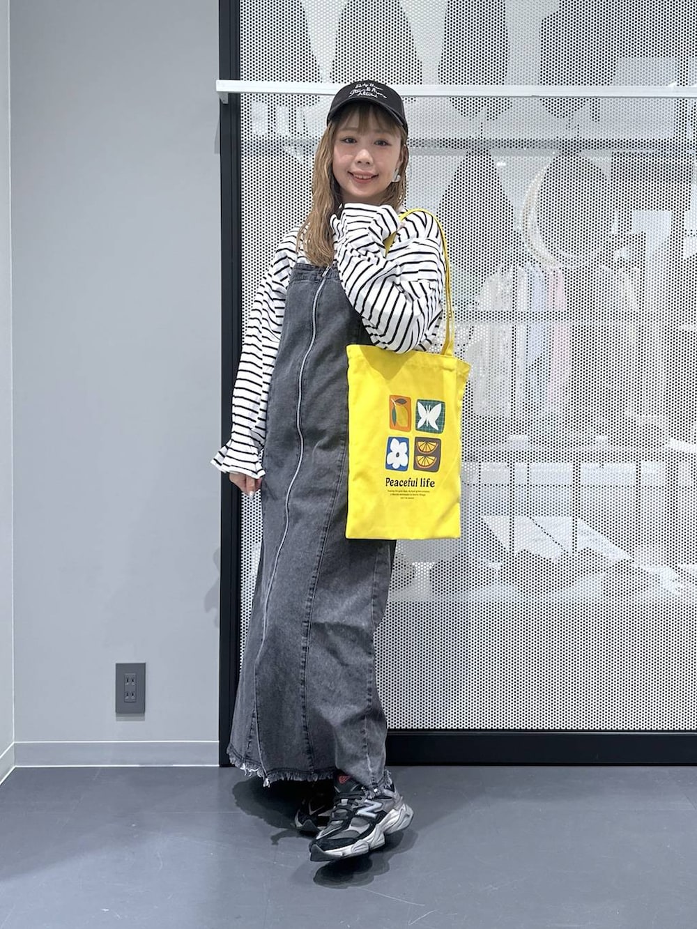 イエロー系のトートバッグ、その他のピアス（両耳用）を着用したレディースの春コーディネートの4枚目の写真