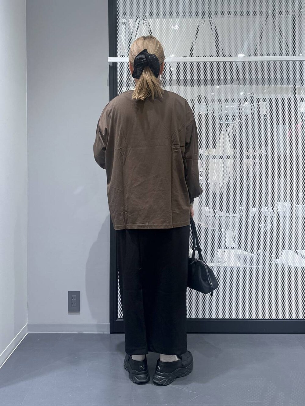 ブラック系のスカート、ブラック系のハンドバッグ、その他のピアス（両耳用）を着用したレディースの秋コーディネートの2枚目の写真