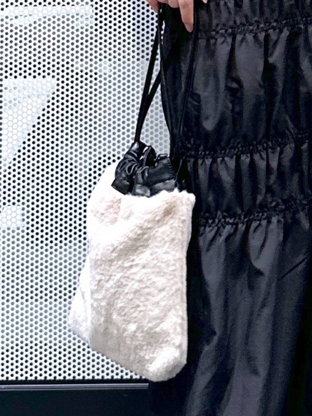 グレー系のニット/セーター、ブラック系のナイロンジャケット、ベージュ系のショルダーバッグを着用したレディースの冬コーディネートの6枚目の写真