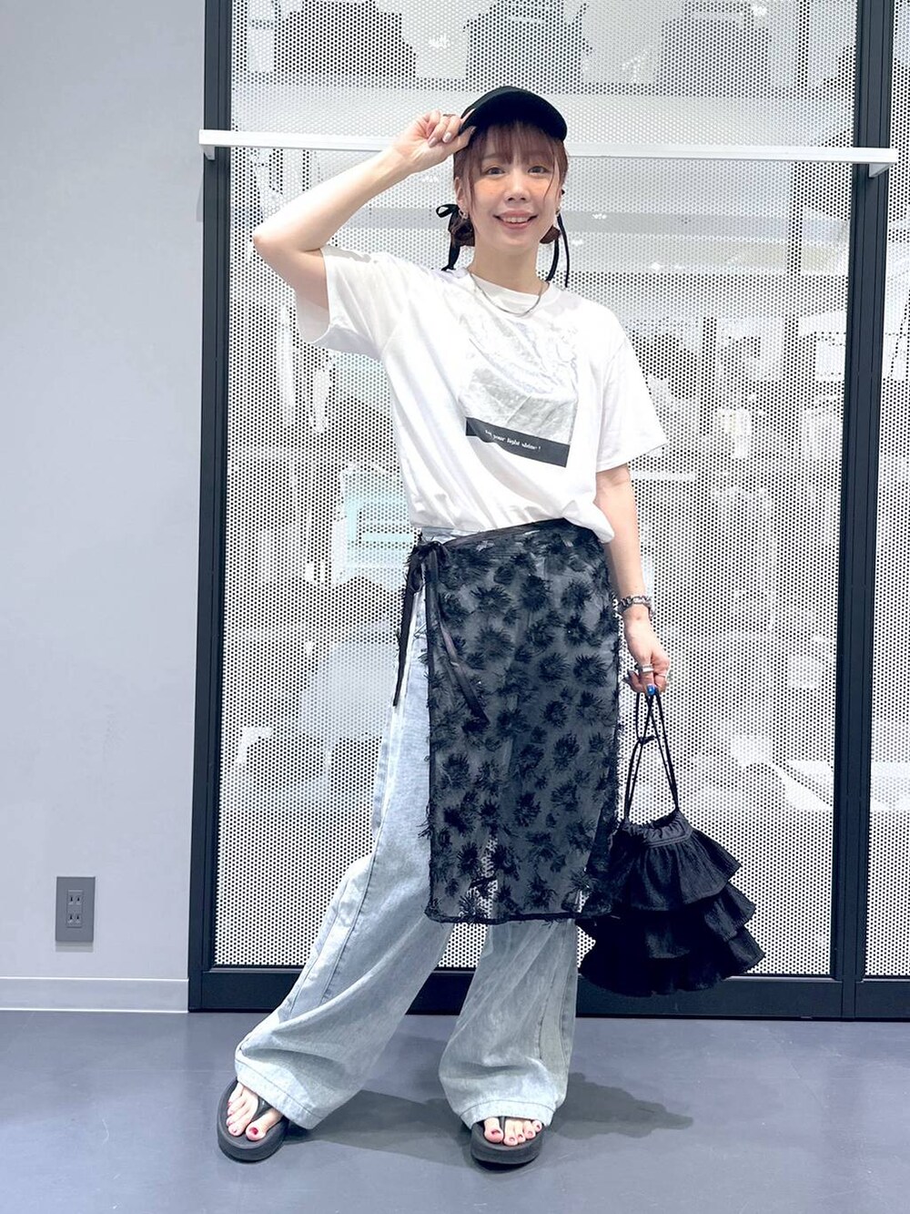ブルー系のデニムパンツ、ホワイト系のTシャツ/カットソー、ブラック系のショルダーバッグを着用したレディースの夏コーディネートの2枚目の写真