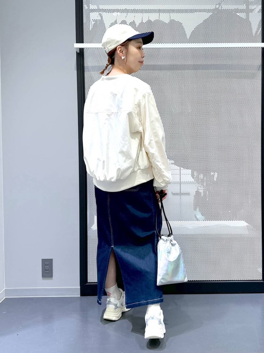 ブルー系のジャンパースカート、ベージュ系のMA-1、ピンク系のニット/セーターを着用したレディースの春コーディネートの3枚目の写真